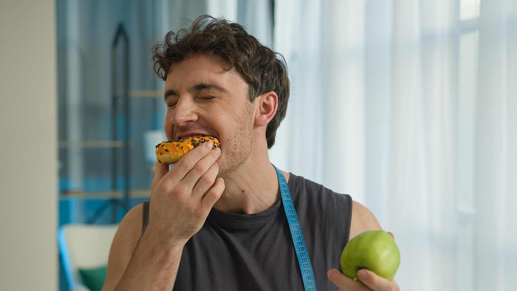 mladý-muž-drží-jablko-a-donut
